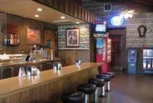 The long wood-paneled counter at Pop’s with a row of black stools